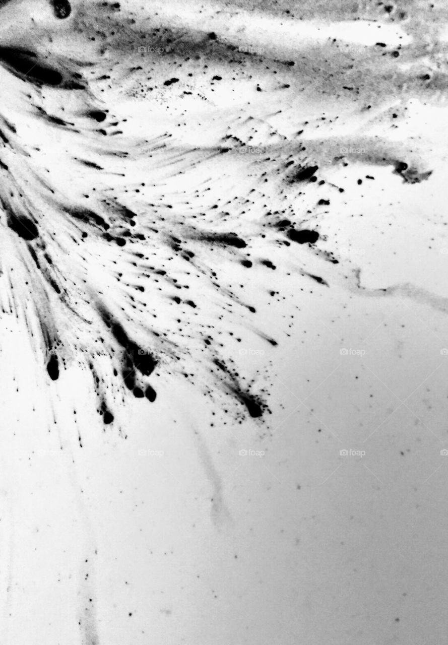 black paint splashing on a white background