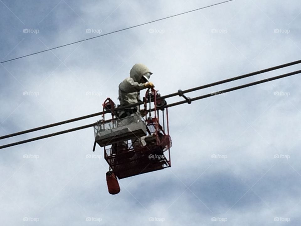 Barehand power lineman working 345,000 volts energized on the wire wearing a Barehand suit. 