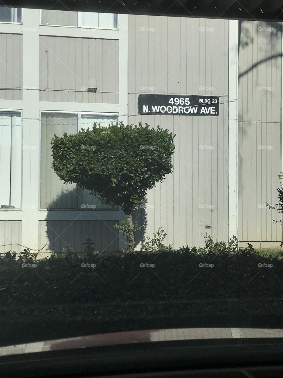 A view of an apartment building from the inside of a vehicle.