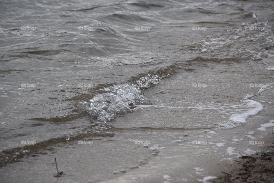 Waves steadily coming on the beach from winter winds