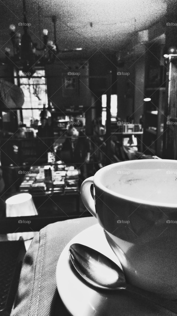 Coffee in the bookstore. Empty coffee cup standing on the sofa in the bookstore