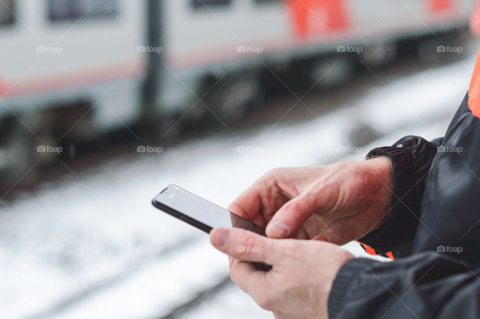 Man using smartphone on the train station in the city