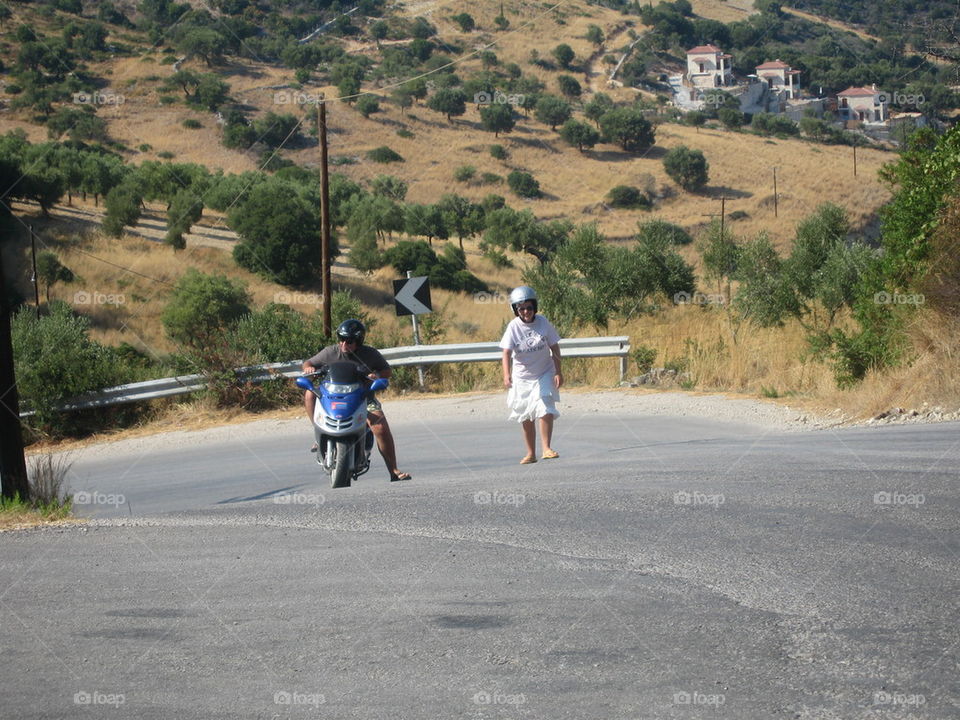 couple strugling with motor bike on a hill