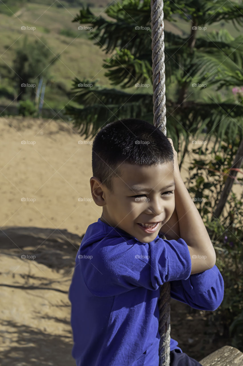 Asean boy at the nodes the rope and smiling happily.