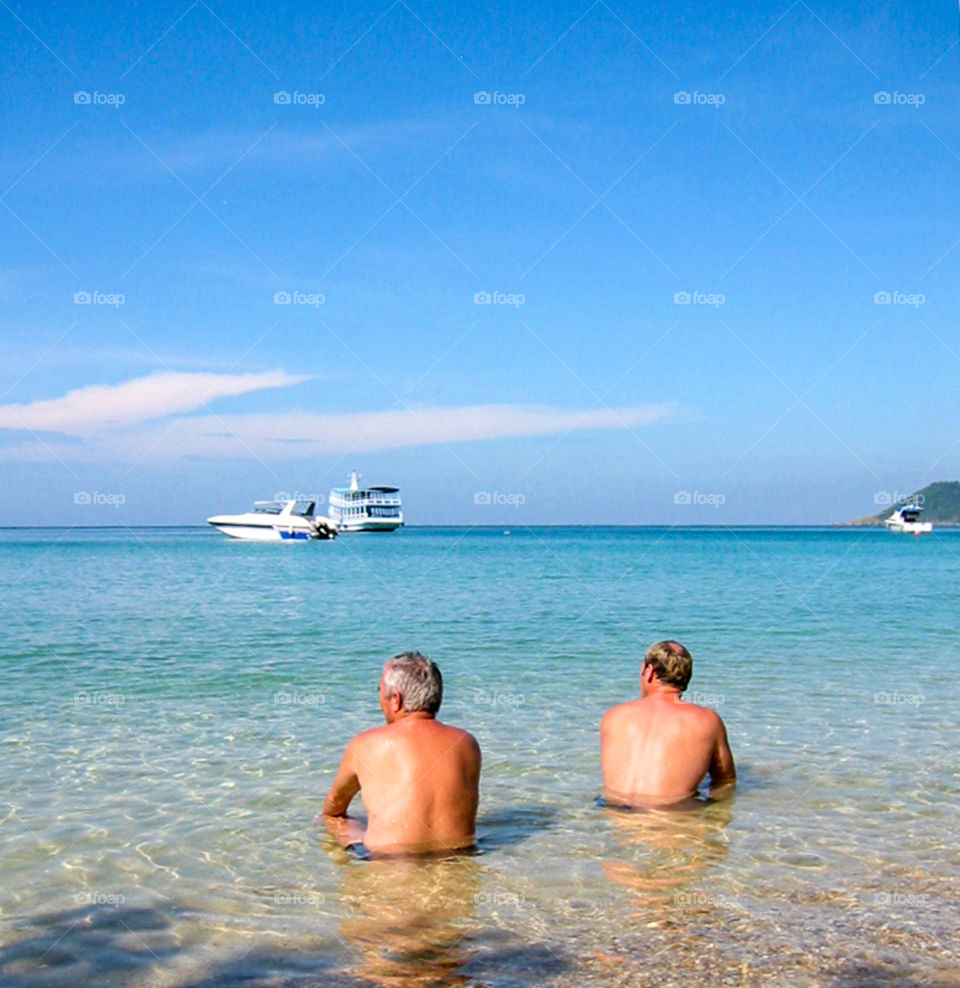 Men sitting in water. 