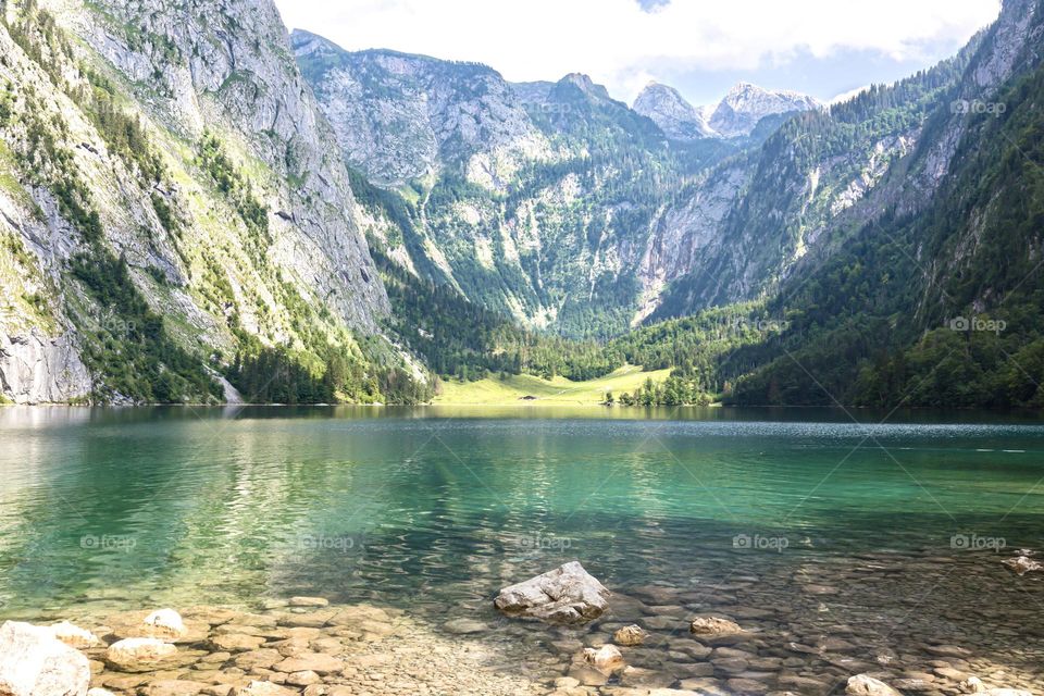 Beautiful mountains surrounding green alpine lake Obersee in Berchtesgaden Germany on a summer day 