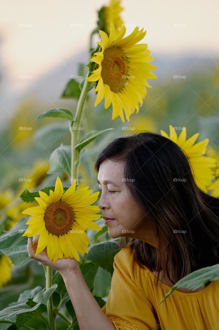 Woman in the middle of sunflower field 