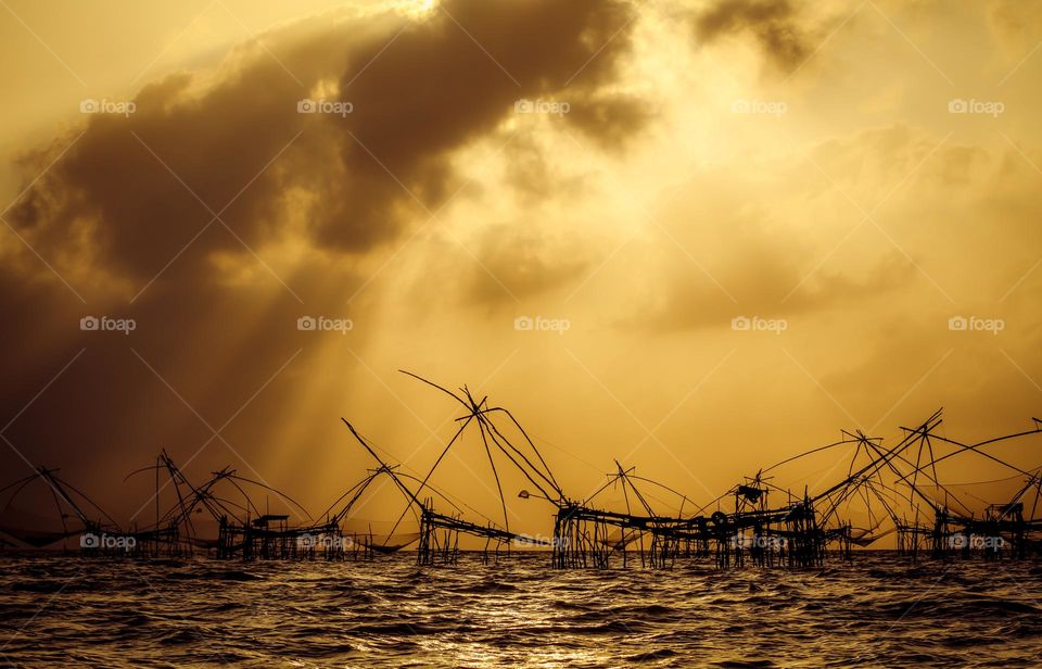 Sunrise time in Patthalung with fishing dip nets silhouettes, amazing Thailand background.