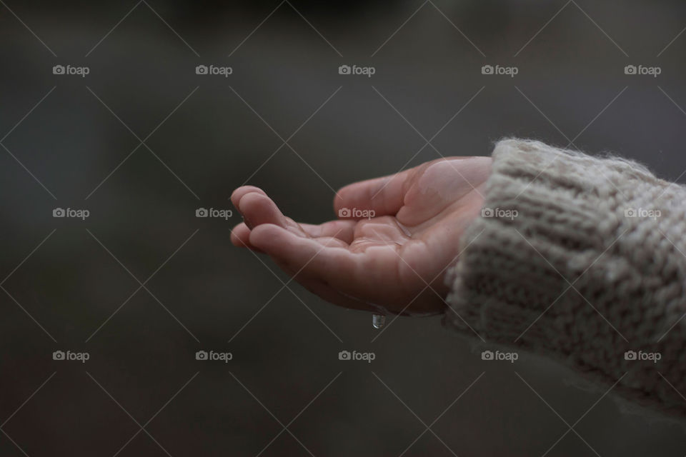 child's hand catching the raindrops