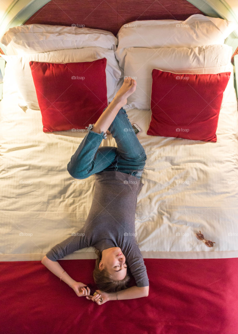 young woman on the bed, top view