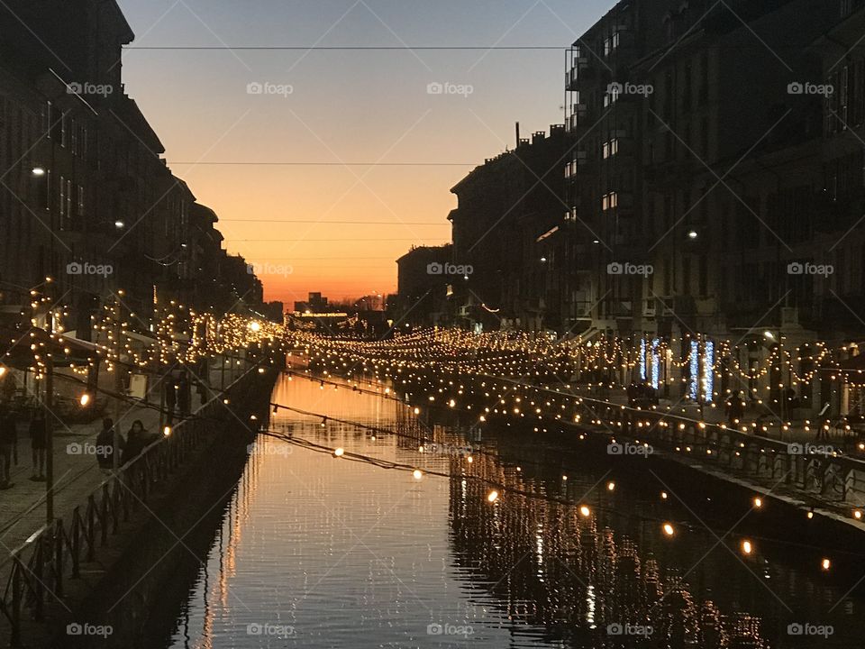 Sunset view on the river in Navigli, Milan. The city was glowing with holiday lights and Christmas decorations. Such a stunning view from a walkway bridge!