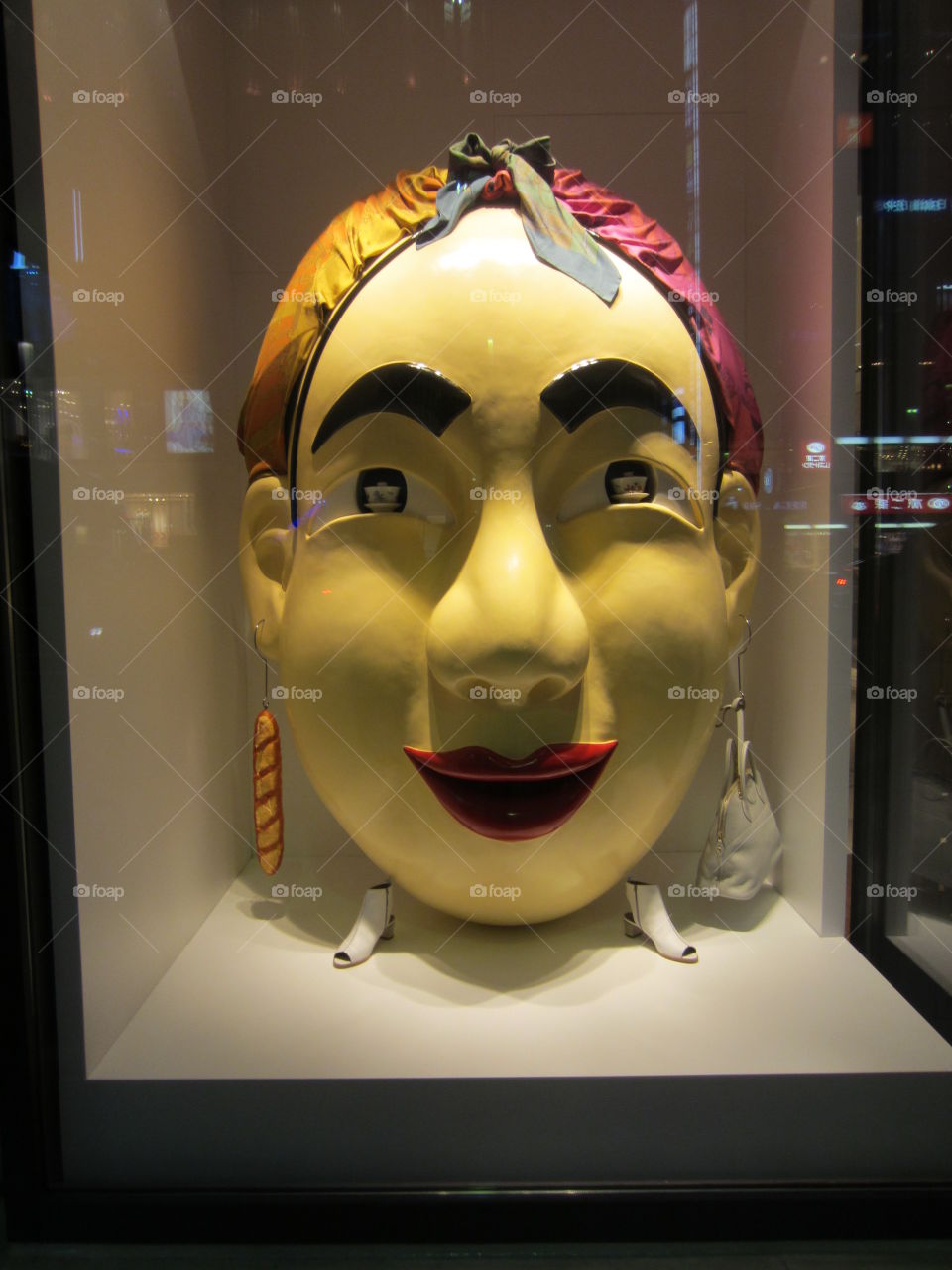 A giant yellow face displayed in a window.  Advertising accessories in Tokyo's Ginza Shopping District