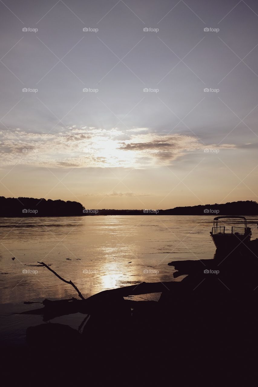 A Boat And Shoreline Silhouetted Against The Sunset In Missouri 