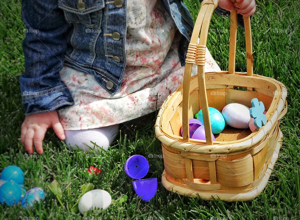 Easter Eggs In A Basket. Young Girl Hunting For Colorful Easter Eggs
