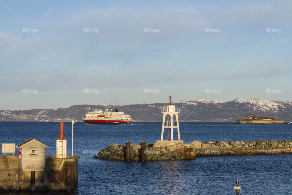 Lighthouse . A cruise passes by a lighthouse in Trodenheim, Norway 