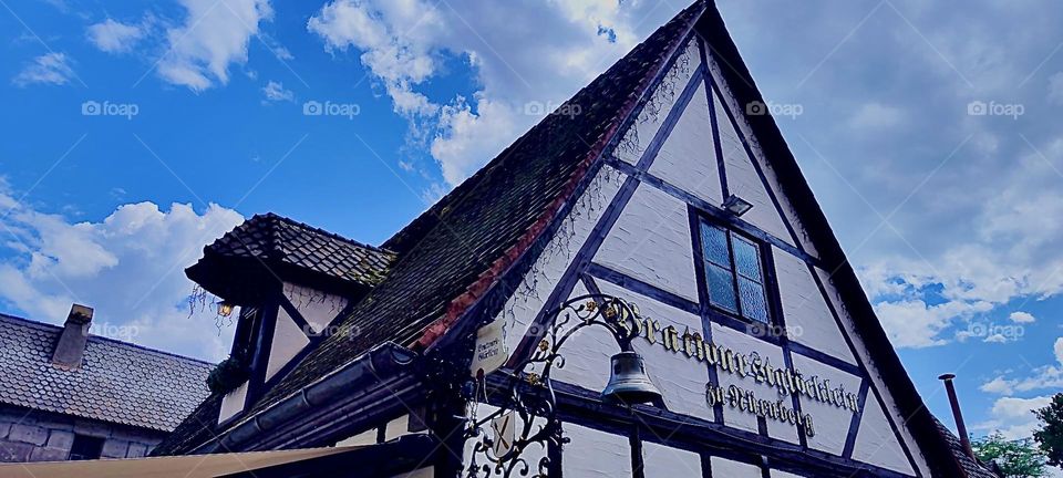 A historical building erected in the style of “Fachwerk”, a type of construction that combines stone masonry or bricks with wood, which consists of exposed structural support beams and ornamental decor. 2023. Hypnotic Productions