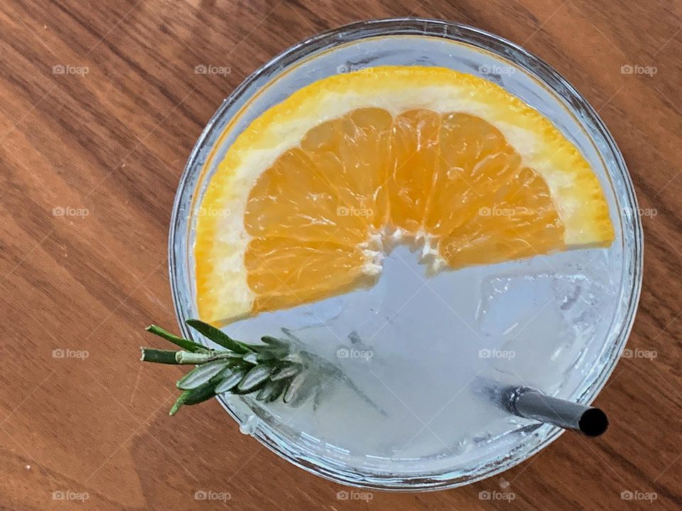 Drink with rosemary, orange slice and ice