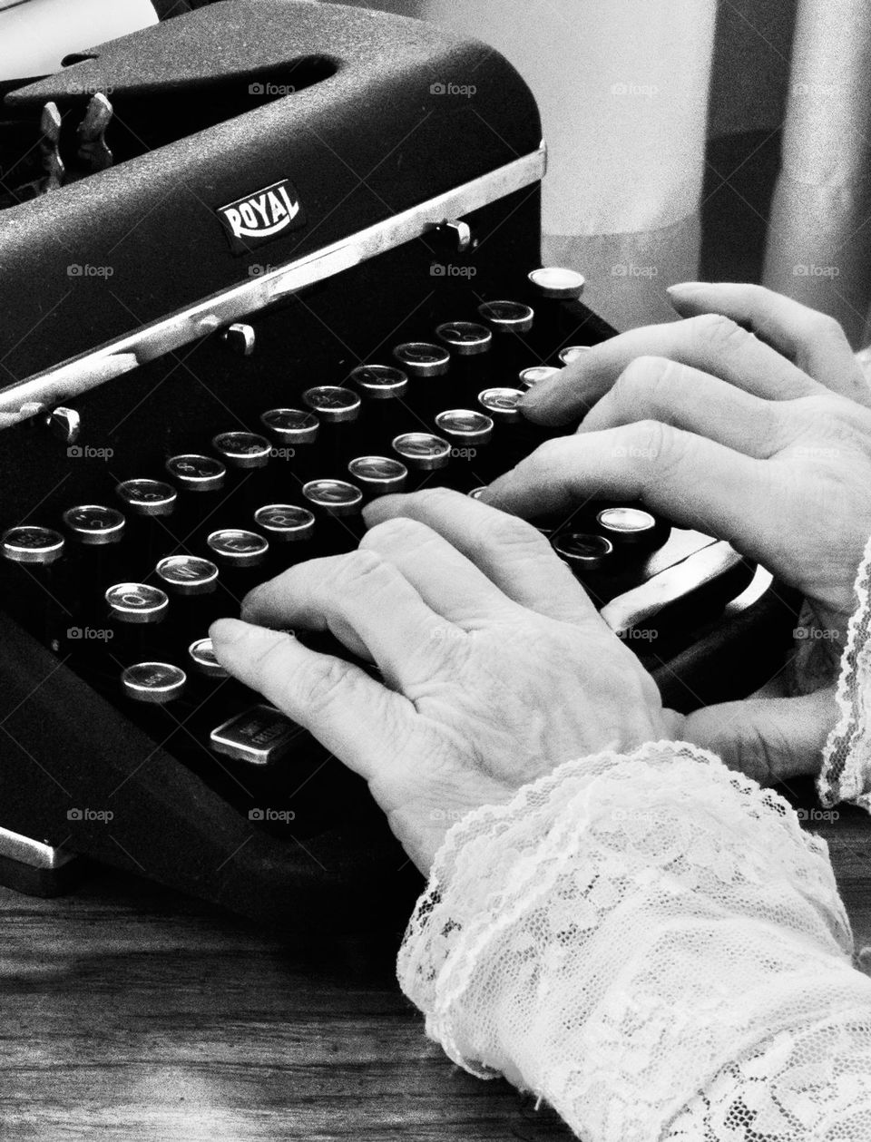 Black and white photo of old typewriter with lady typing