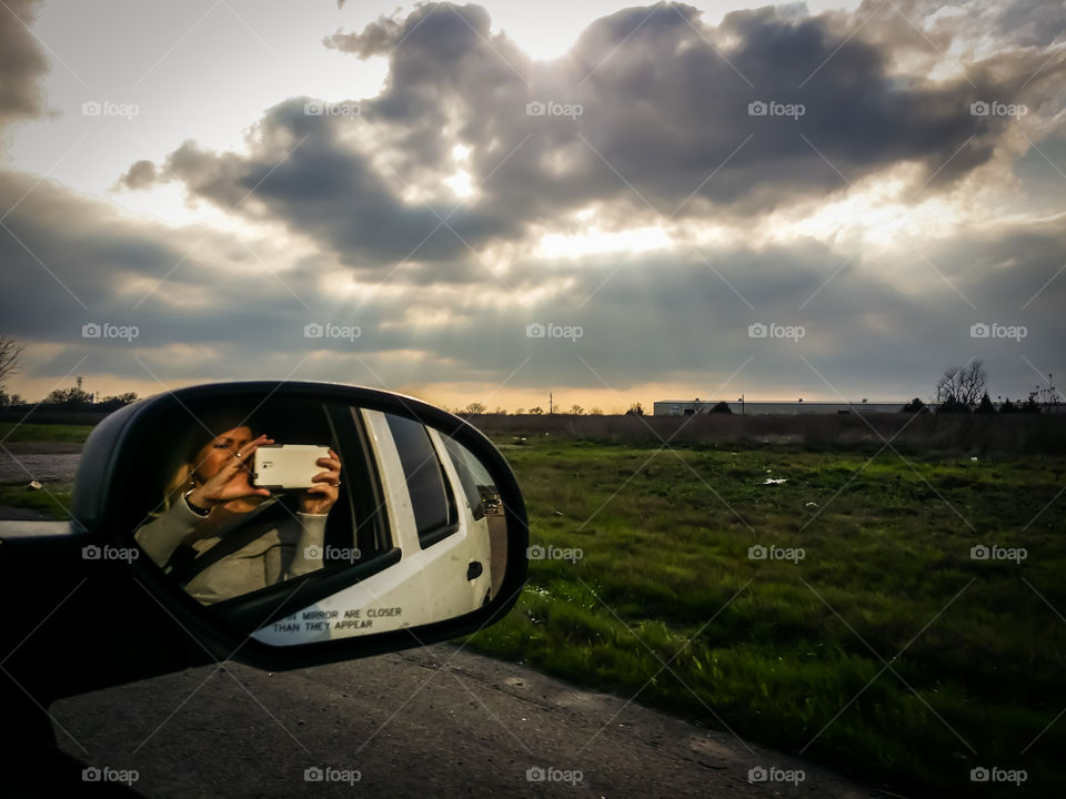 View of a woman photographing from a car