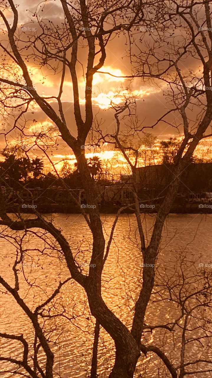 Evening sunset Reflective silhouette on Lake Water with Evening Colors timing for Sunset. Mostly Cloudy Heavy Clouds building for Strong Weather Front Headed to this Region. 