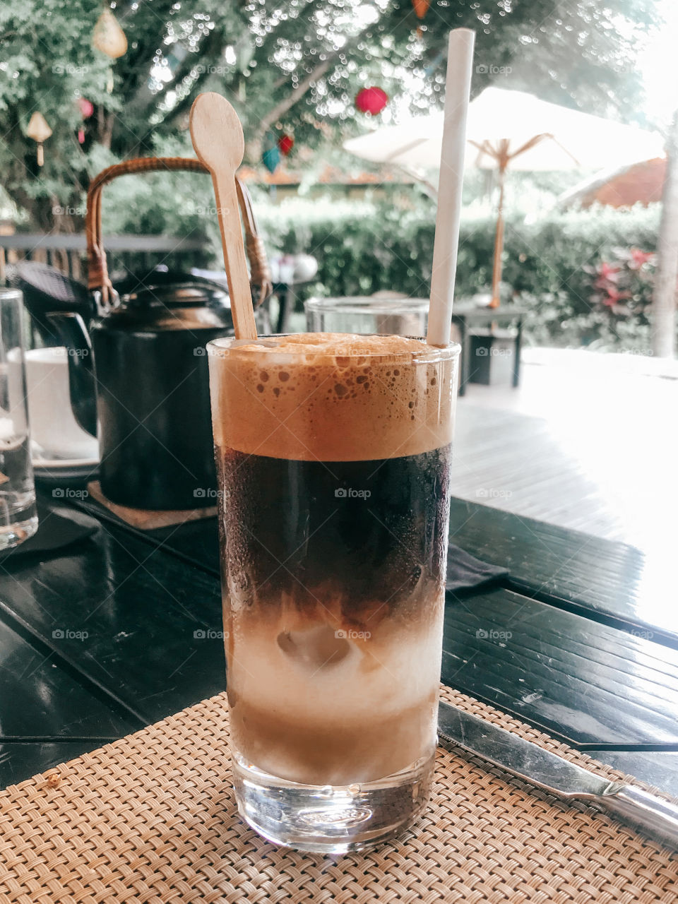 Ice coffee with different layers and colors . morning coffee .  Coffee glass are placed on a black wooden table . 