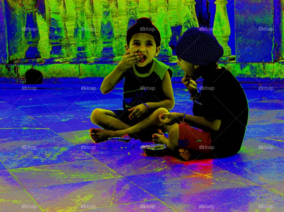 This picture was described about two children who belong to Sikh community from India eating happily" prasada"(god's food).