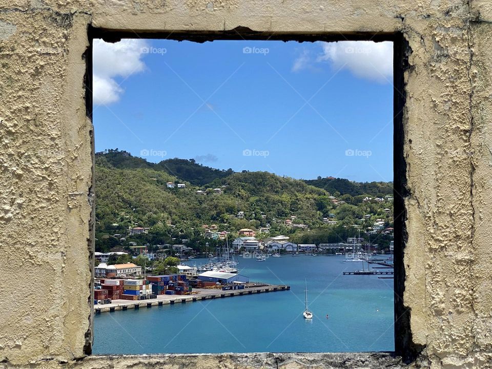 Looking through a window to a beautiful view of blue water and some hills
