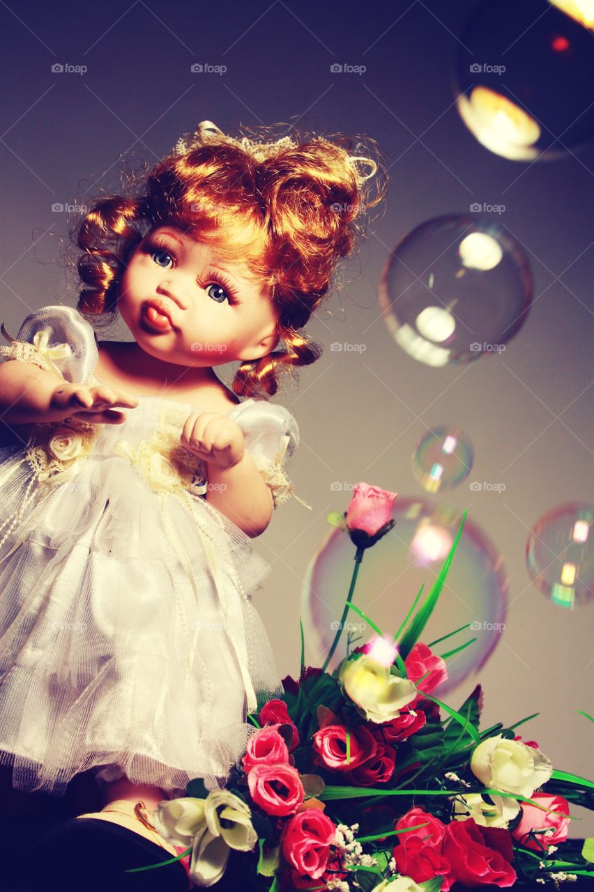 beautiful doll with flowers and soap bubbles