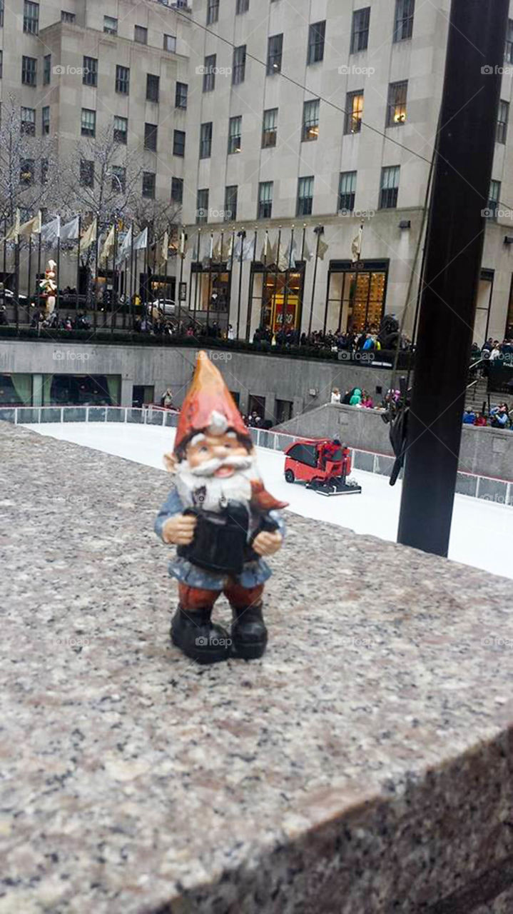 Gnome in NYC. Traveling gnome visits Rockefeller Center in New York City to watch the ice skaters