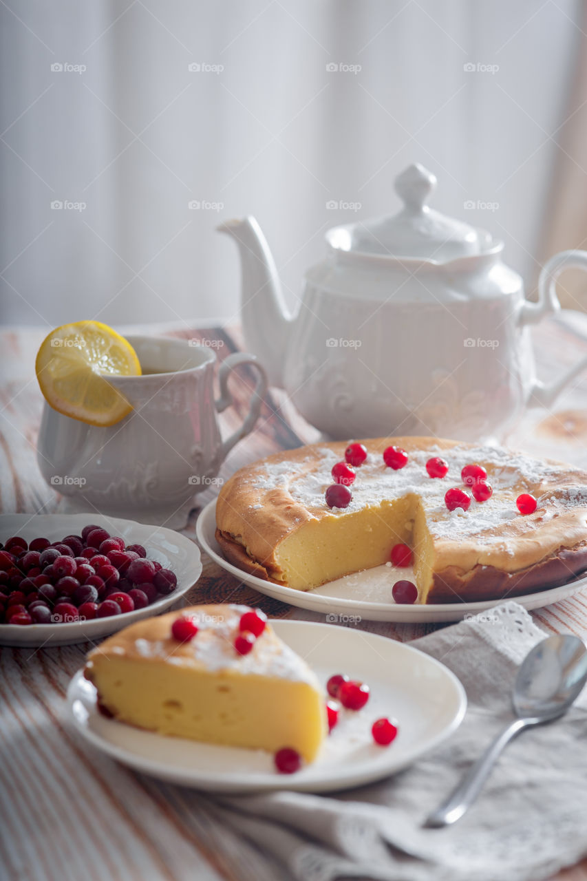 Cheesecake with cranberries and sugar on wooden background