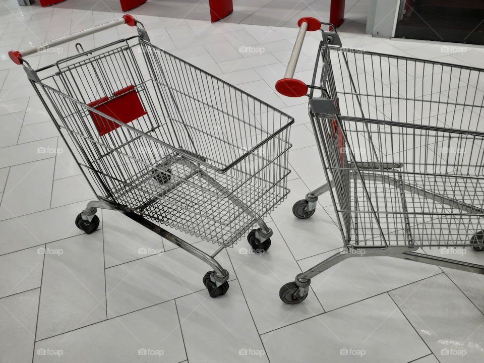 Carts for grocery products stand near a supermarket on the street