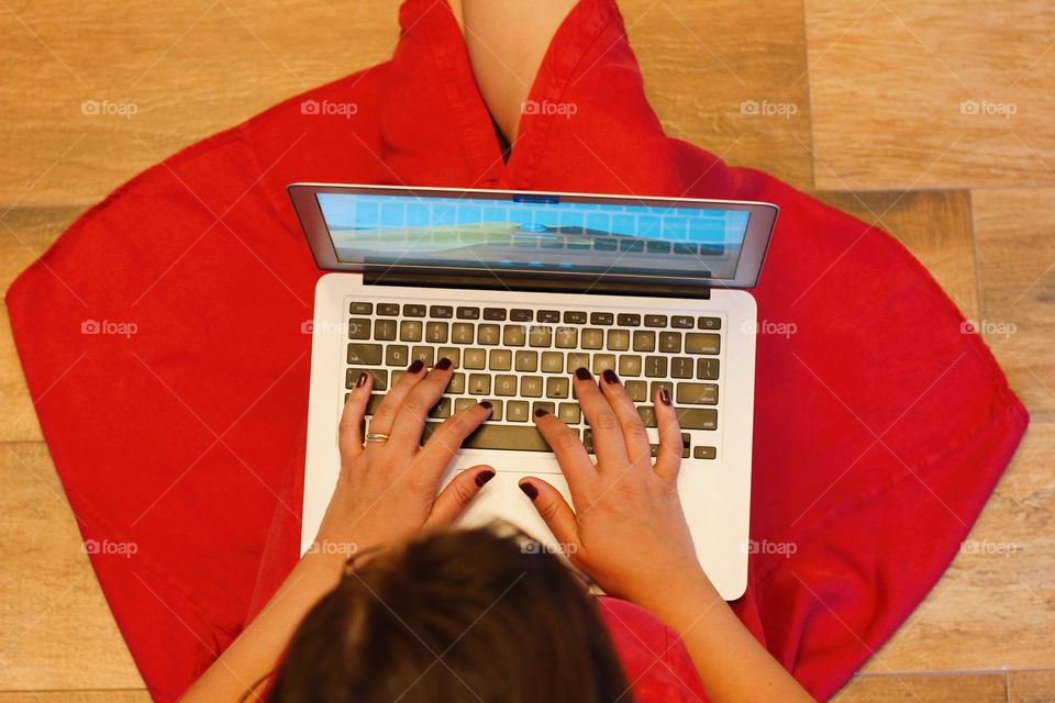 woman in red dress using macbook