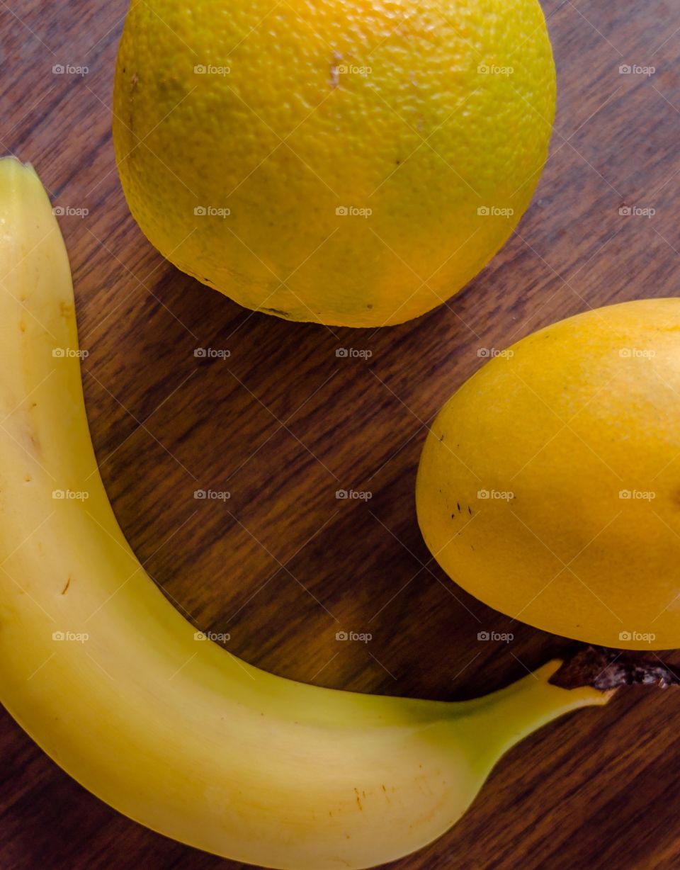 Fruits on the table . Close up banana, mango and orange