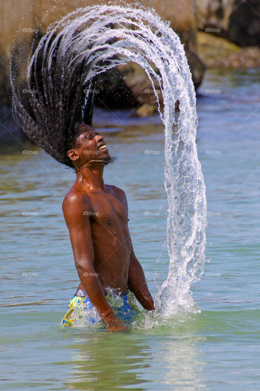 Man tossing water in the sea with his hairs