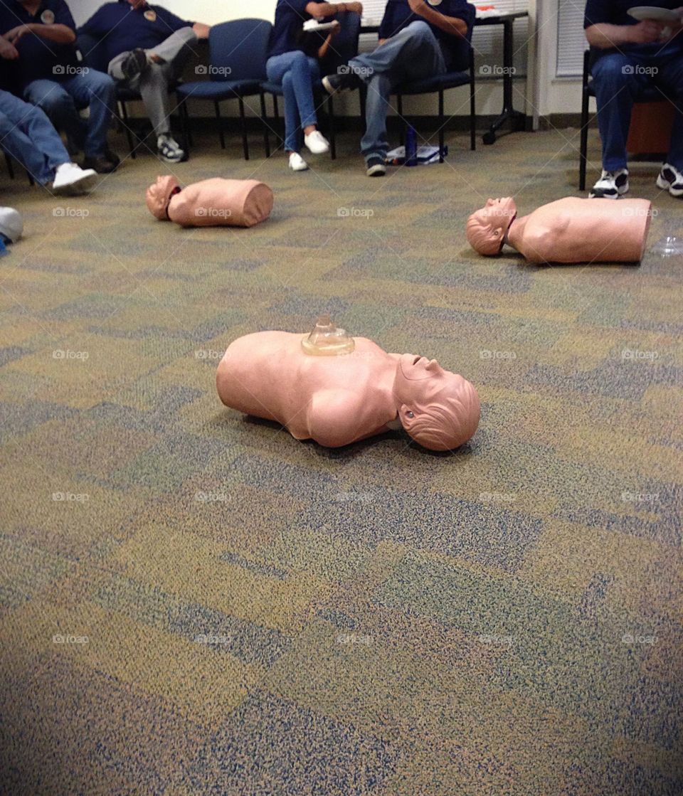 CPR class with lifelike models on the floor.