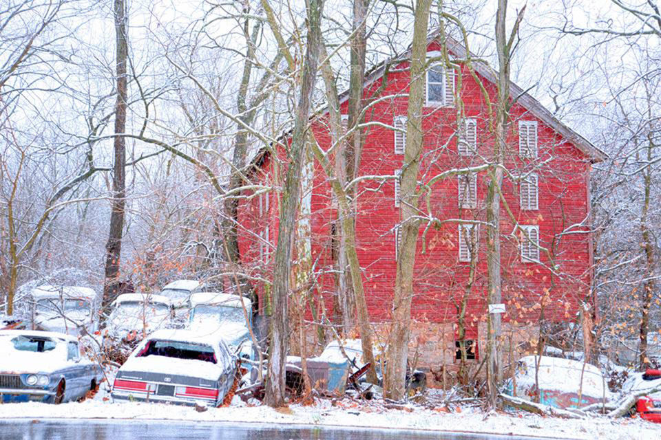 junkyard barn. junkyard cars surround old red barn