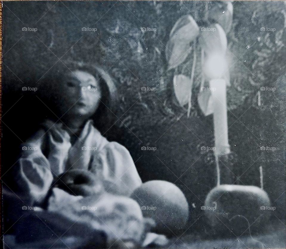 This is a digital reproduction of a „Camera Obscura“ black and white photograph from the 1980s. It shows a handmade doll wearing a silk blouse by candlelight. 2023. Hypnotic Productions