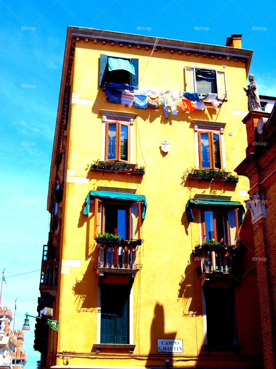 laundry drying outside of a Italian yellow house