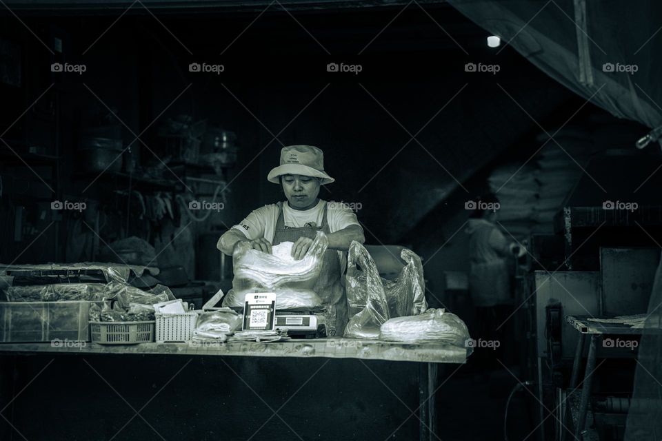 A lady is selling bread in street .