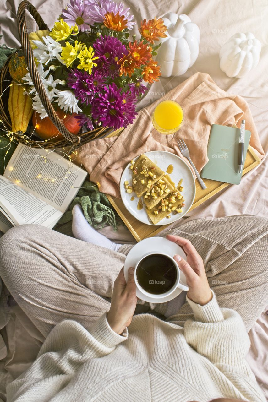 Girl sitting in bed and having breakfast 