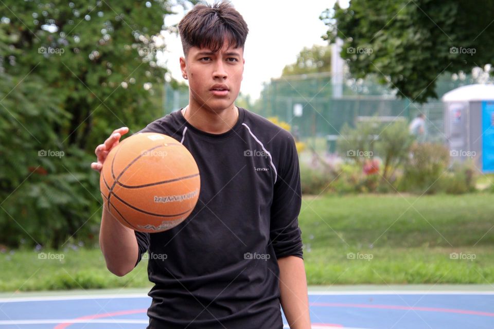 Teenage boy is practicing his basketball skills