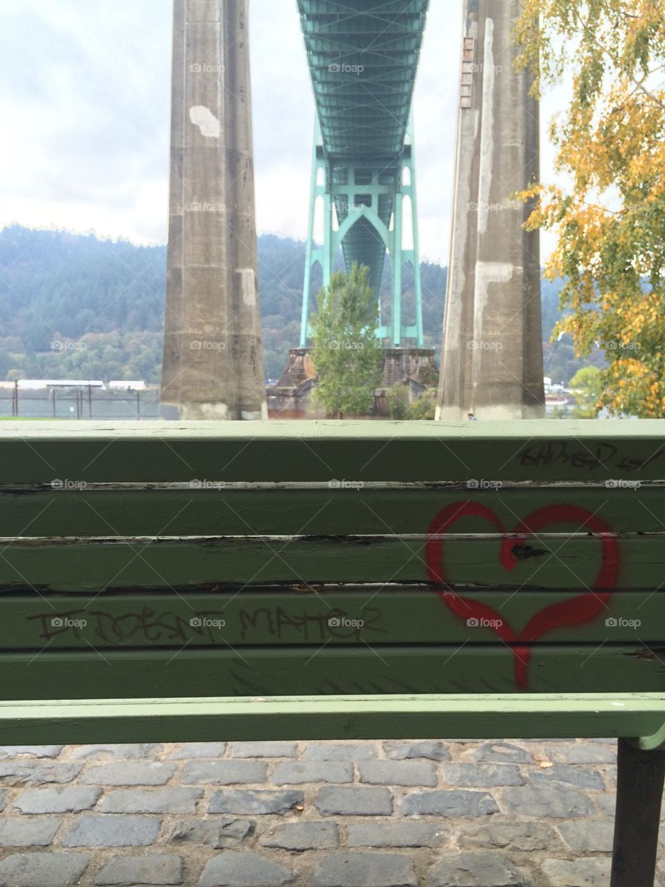 A bench with graffiti on it underneath St. John's Bridge in Portland, Oregon.