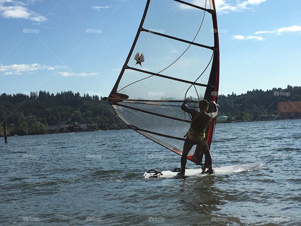 Asian man windsurfing in harbour near Vancouver 