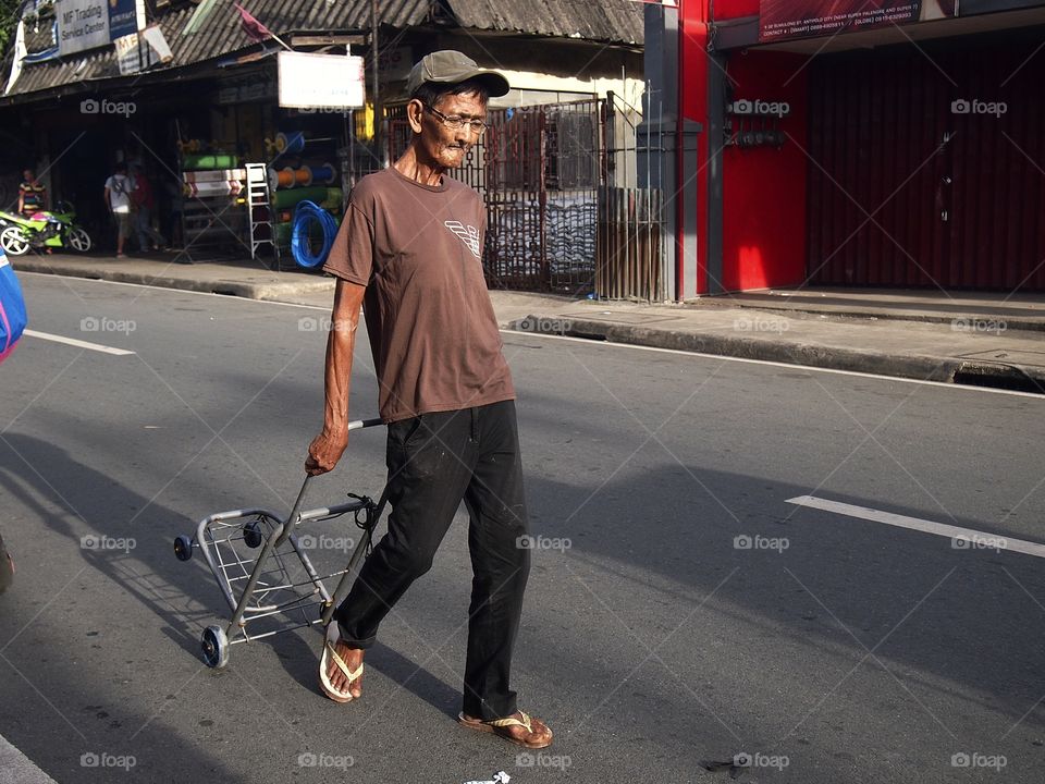man walking in the street with a stroller