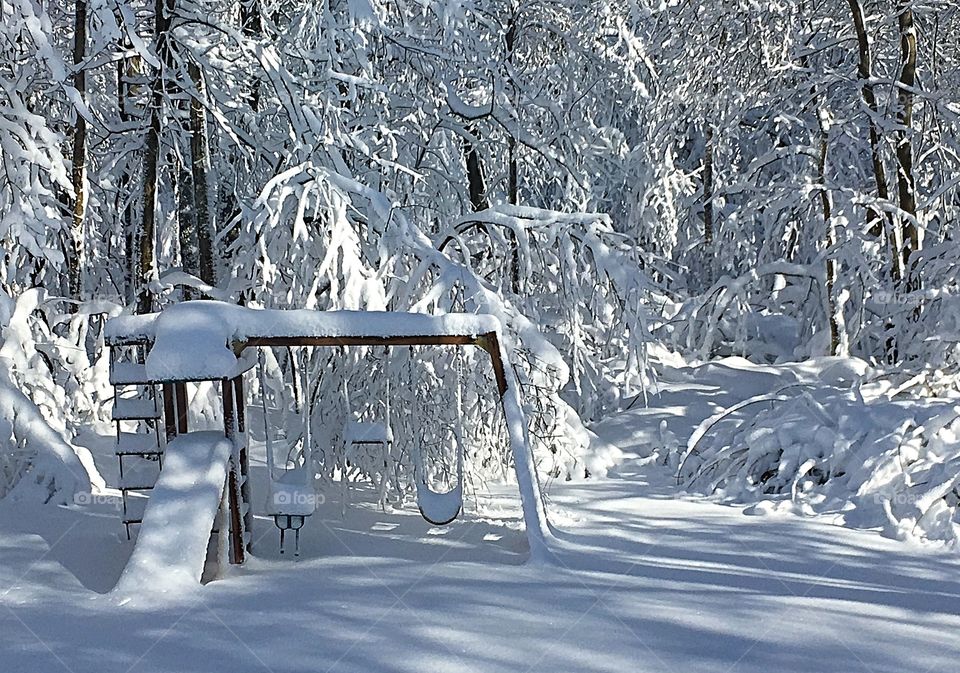 Goodbye Winter, hello Summer.  Late winter snow covers the backyard, swingset and trees. 