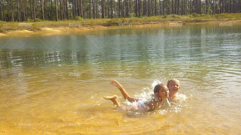 Brother and sisters bathing in lake