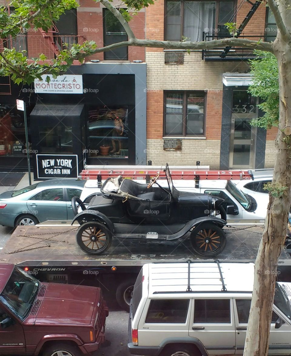 Antique Car on the back of a truck