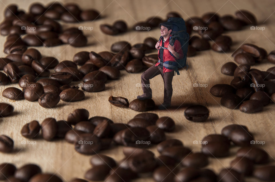 Compositing of a hiker walking on a coffee beans field