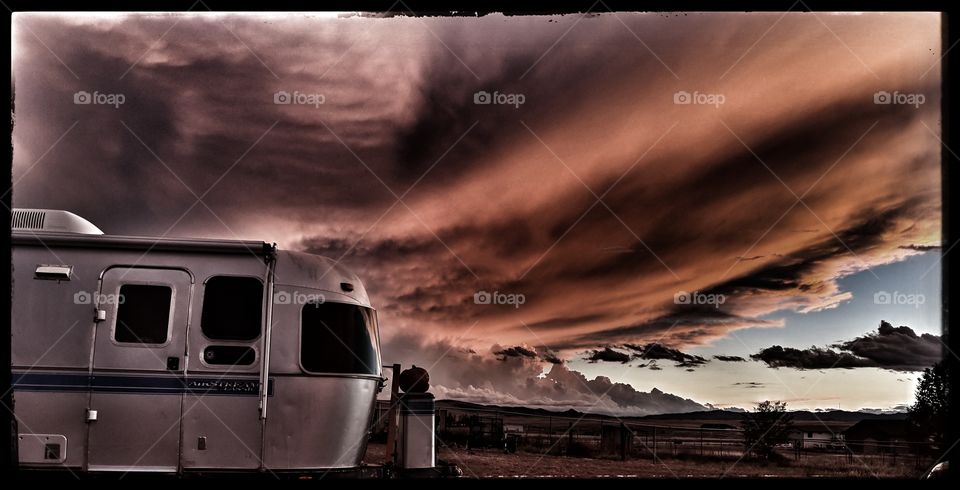 Vintage Airstream after the storm under apocalyptic skies.