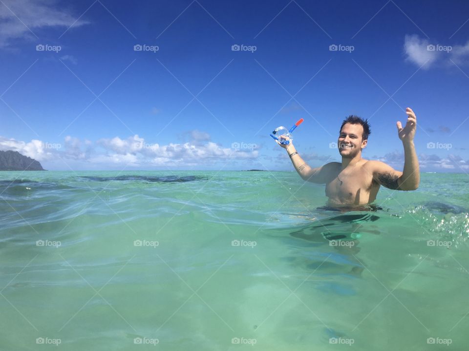 Young man having fun and holding snorkel goggles 